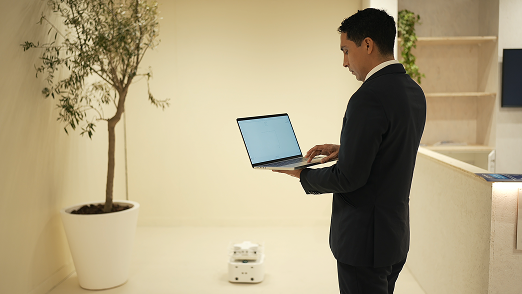 Surveyor working on a laptop next to the Mesa robot